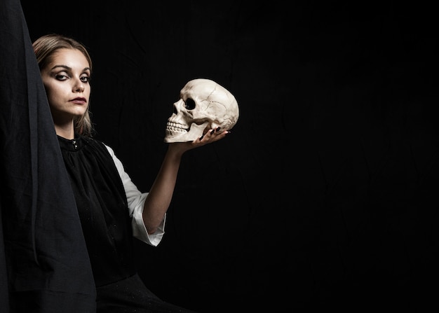 Woman holding skull with copy space