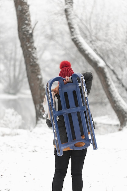 Woman holding a sleigh outdoors