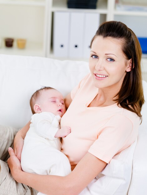 Woman holding slepping newborn baby