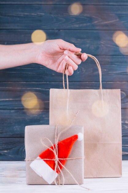 Woman holding small gift bag near gift box