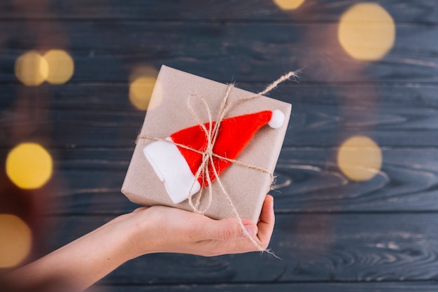 Foto gratuita donna che tiene piccolo regalo con cappello santa