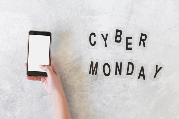 Женщина, держащая смартфон возле надписи Cyber ​​Monday