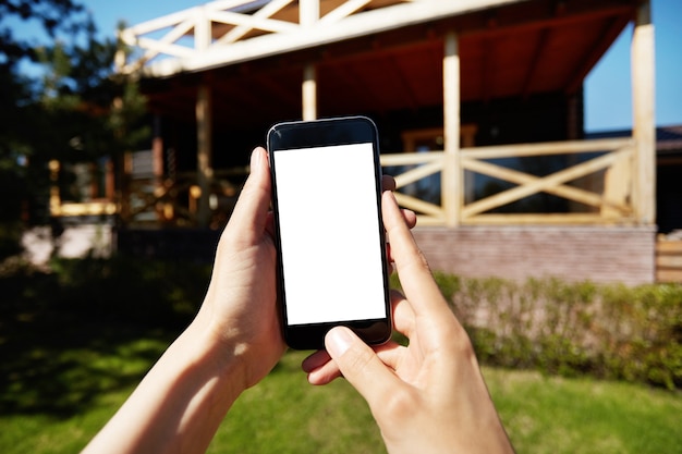 Woman holding smartphone with blank white screen