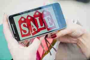 Free photo woman holding smartphone with inscription on screen