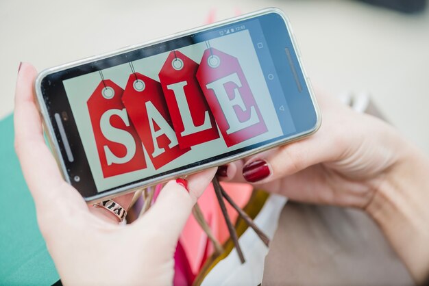 Woman holding smartphone with inscription on screen