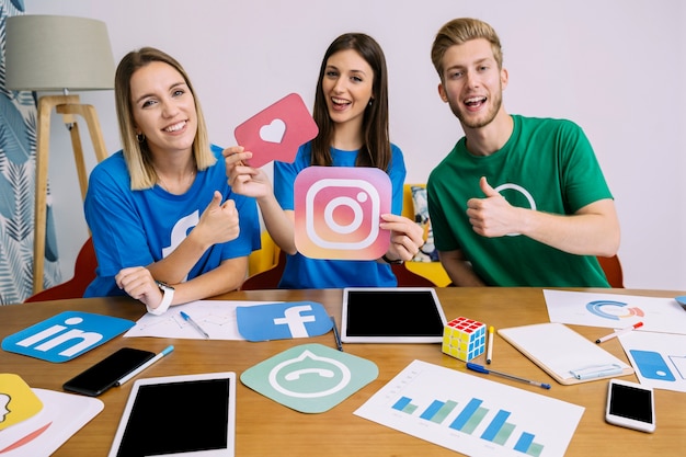 Woman holding snapchat logo with his friends showing thumbup sign