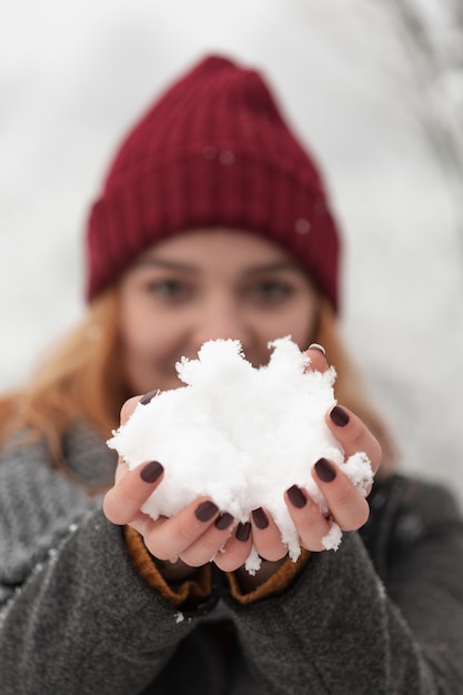 Бесплатное фото Женщина держит в руках снег