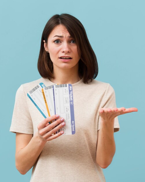 Woman holding some airplane tickets looking concerned