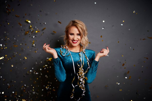 Woman holding something on her hand under shower of confetti