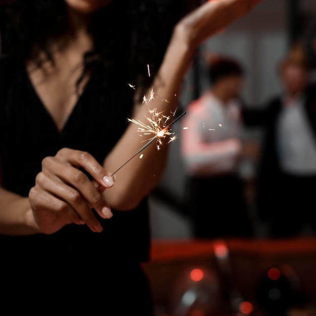 Free photo woman holding sparklers at new year's eve party