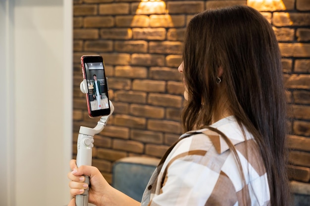 Foto gratuita una donna che tiene uno stabilizzatore con il telefono