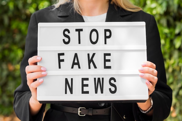 Woman holding stop fake news sign