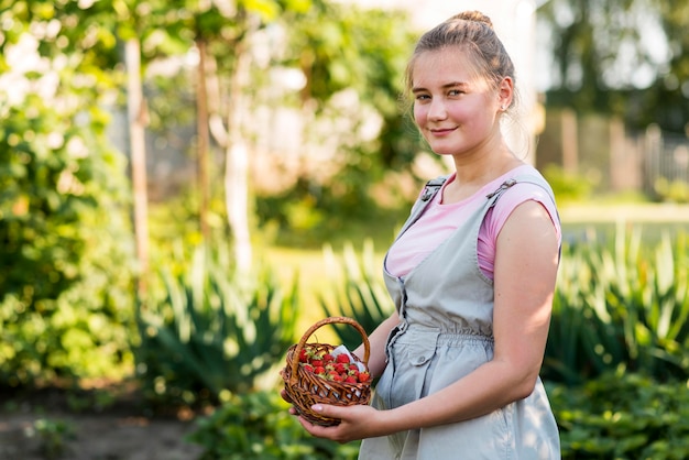 Foto gratuita canestro delle fragole della tenuta della donna