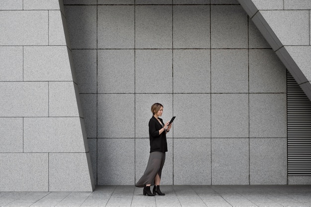 Woman holding tablet full shot