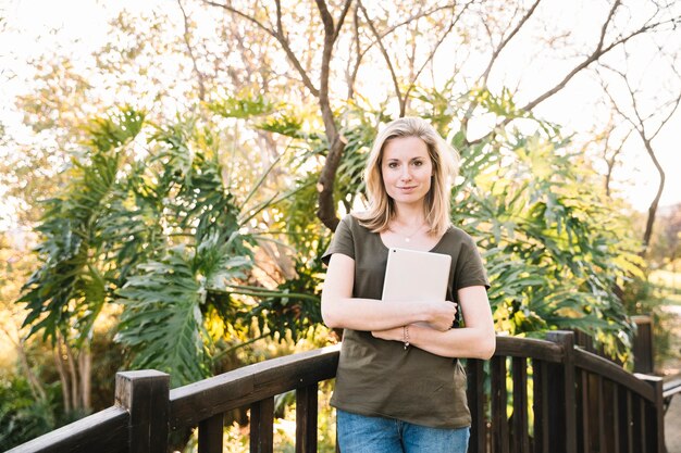 Woman holding tablet and looking at camera