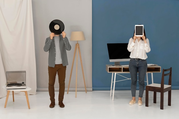 Woman holding tablet and man holding vinyl