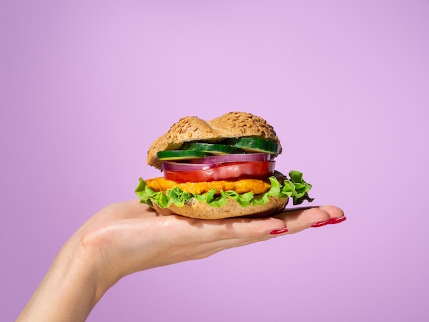 Woman holding a tasty burger in her palm