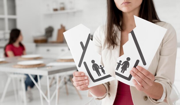 Woman holding torn apart family drawing