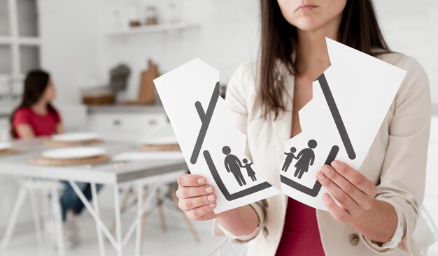 woman holding torn apart family drawing