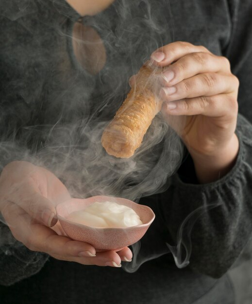 Woman holding traditional tequenos dish