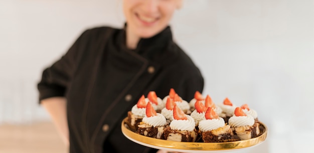 Woman holding tray with dessert close up