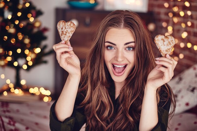 Woman holding two heart-shaped biscuits