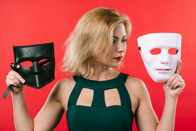 Free photo woman holding two masks in hands