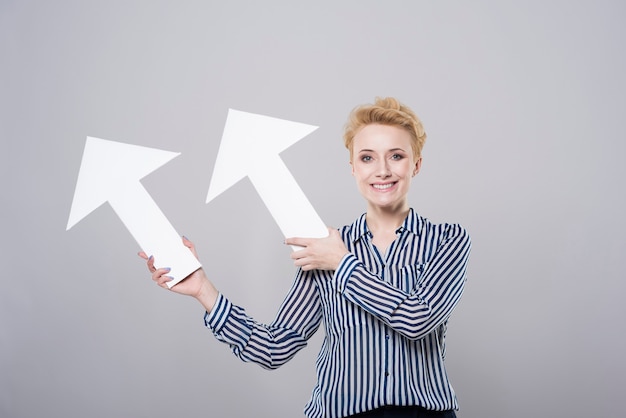 Free photo woman holding two white arrows