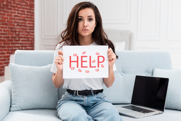 Woman holding up a help sign for likes