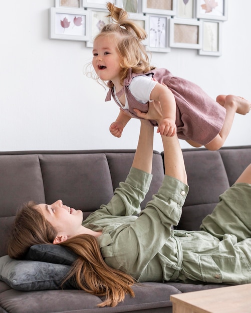 Woman holding up little girl