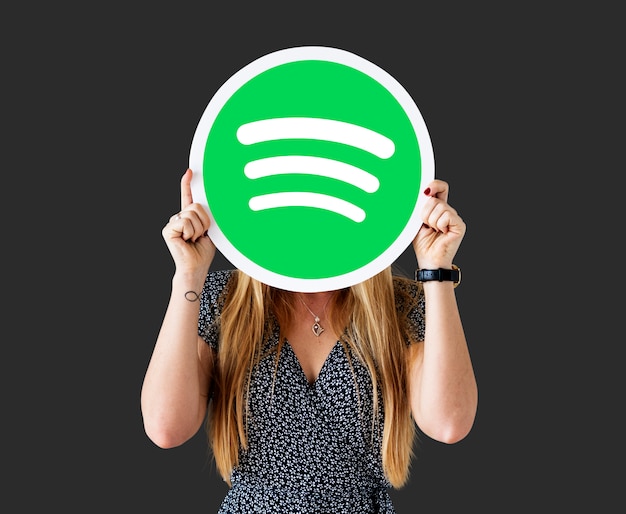 Free photo woman holding up a spotify icon isolated