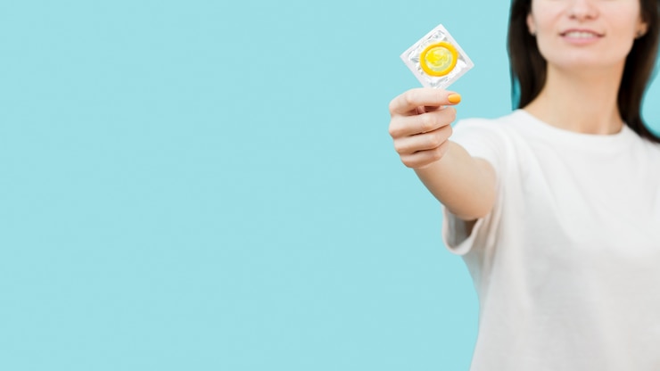 無料Photo コピースペースと黄色のコンドームを保持している女性