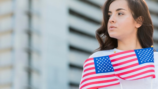 Free photo woman holding usa flags looking away