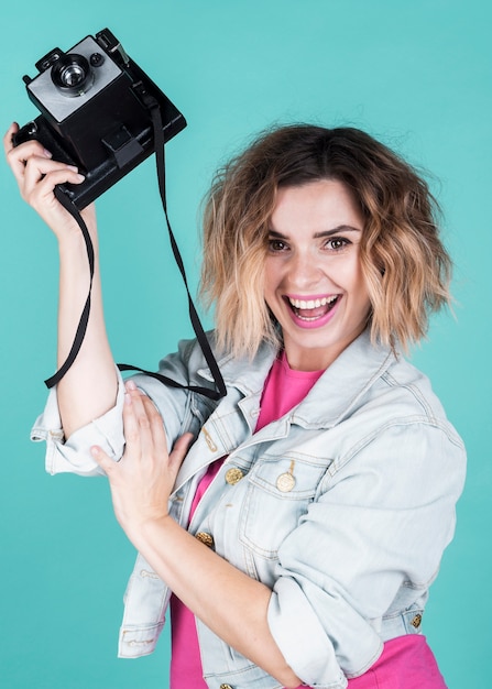 Woman holding vintage camera medium shot