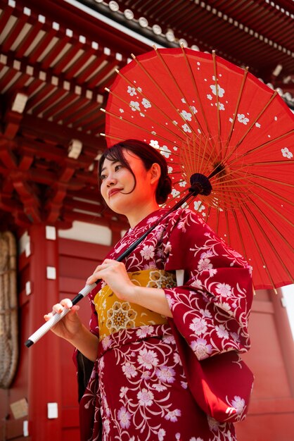 Женщина держит зонтик вагаса под низким углом