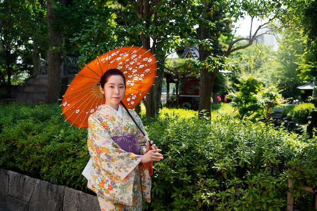 Free photo woman holding wagasa umbrella side view