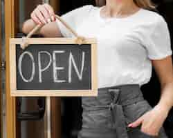 Free photo woman holding we are open sign