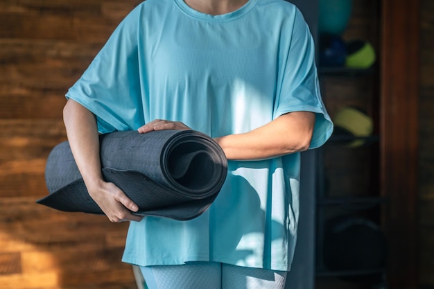 Woman holding yoga mat for fitness in gym health or wellness workout