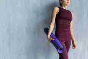 Free photo woman holding a yoga mat