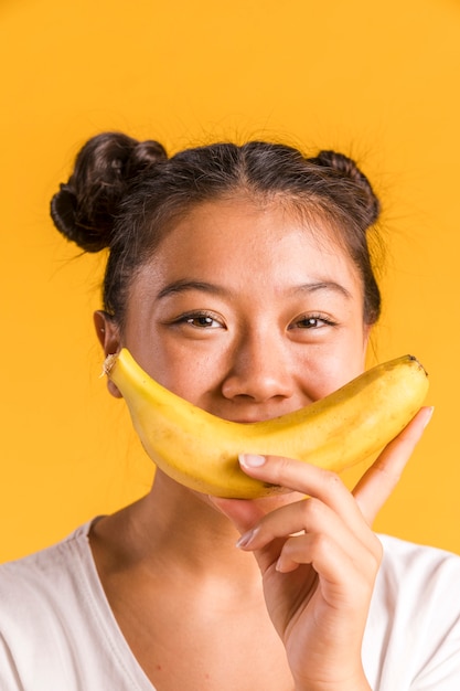 Женщина держит банан в виде улыбающейся фигуры