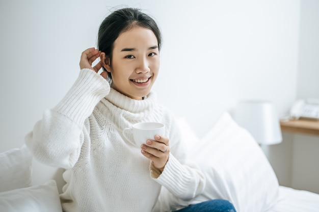 女性は一杯のコーヒーを保持しています。