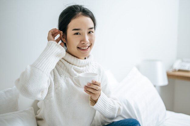 A woman holds a cup of coffee.