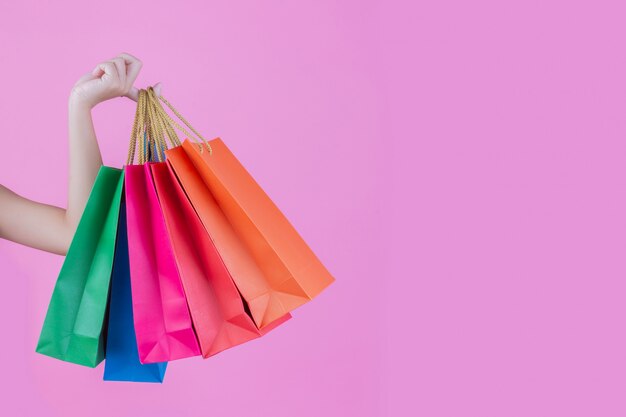 The woman holds a fashion shopping bag and beauty