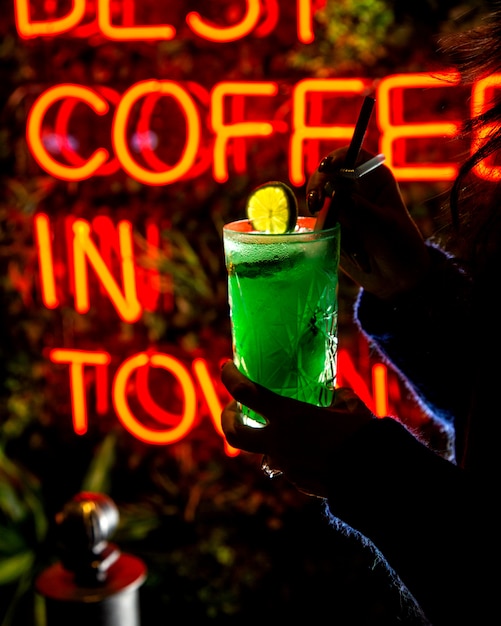 Woman holds green refreshing beverage