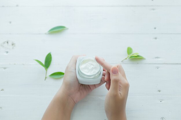 woman holds a jar with a cosmetic cream in her hands