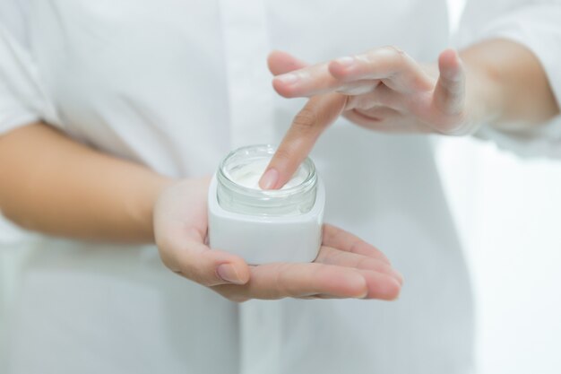 woman holds a jar with a cosmetic cream in her hands