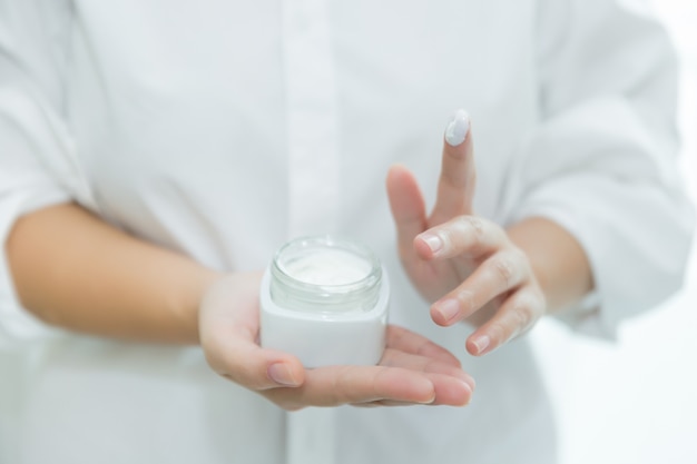 woman holds a jar with a cosmetic cream in her hands