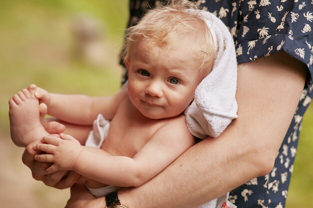 女性は彼女の優しい腕の中で小さな男の子を保持します