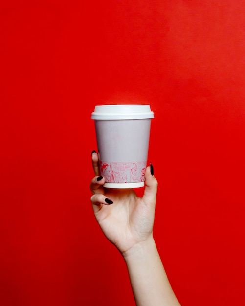 Free photo woman holds plastic cup of coffee