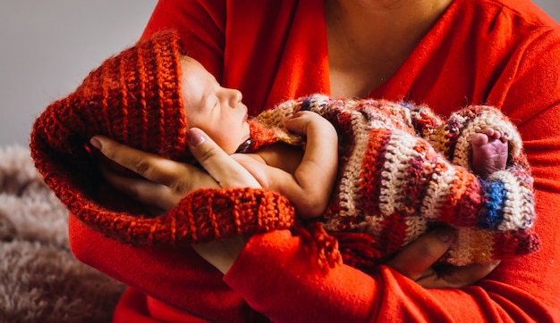 Woman holds pretty newborn baby in her arms 